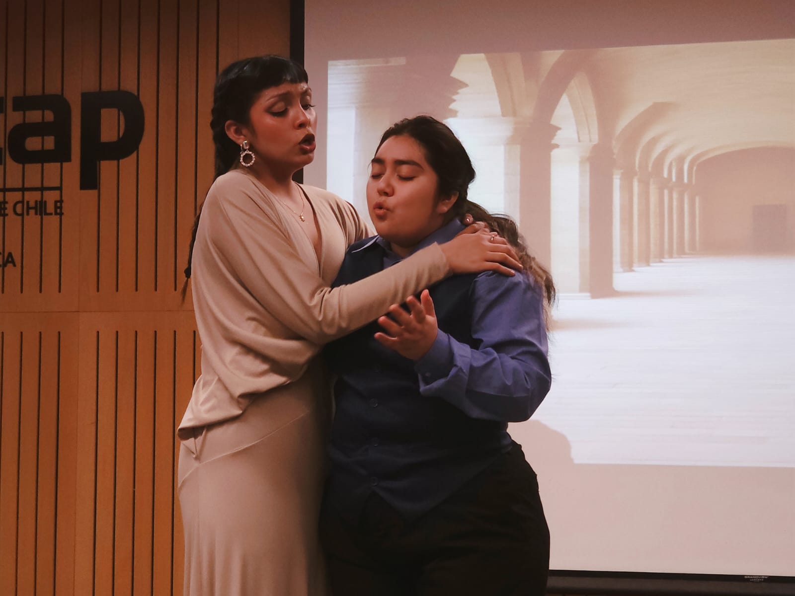 Dos mujeres interactuando en escena de ópera